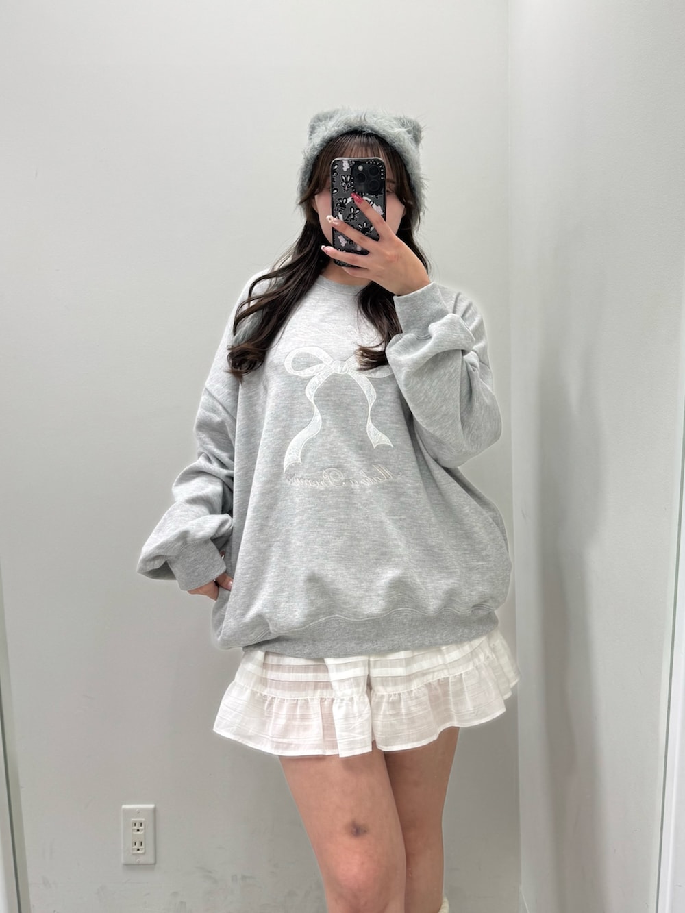 グレー系のTシャツ/カットソー、ホワイト系のスカート、ホワイト系のスニーカーを着用したレディースの冬コーディネートの2枚目の写真