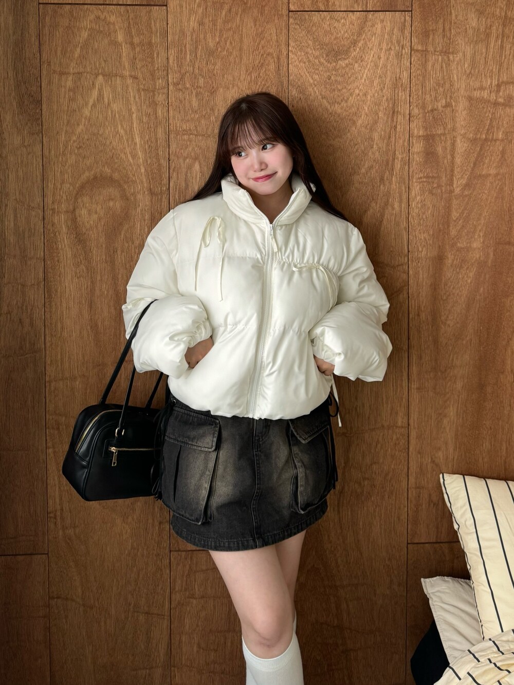 ホワイト系のダウンジャケット/コート、ブラック系のスカート、ブラック系のショルダーバッグを着用したレディースの秋コーディネートの2枚目の写真