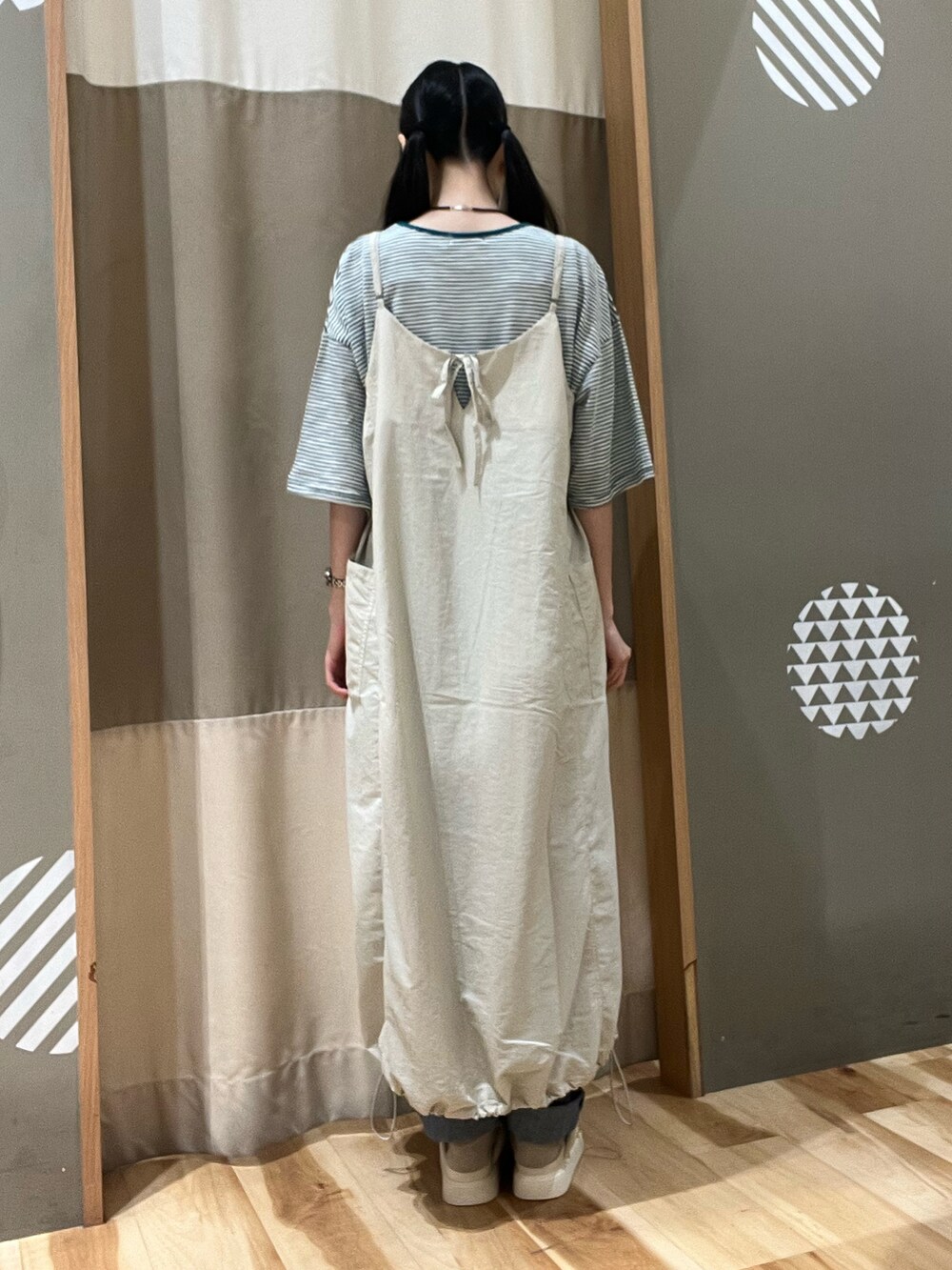 ゴールド系のハンドバッグ、ホワイト系のサンダル、グリーン系のTシャツ/カットソーを着用したレディースの夏コーディネートの3枚目の写真