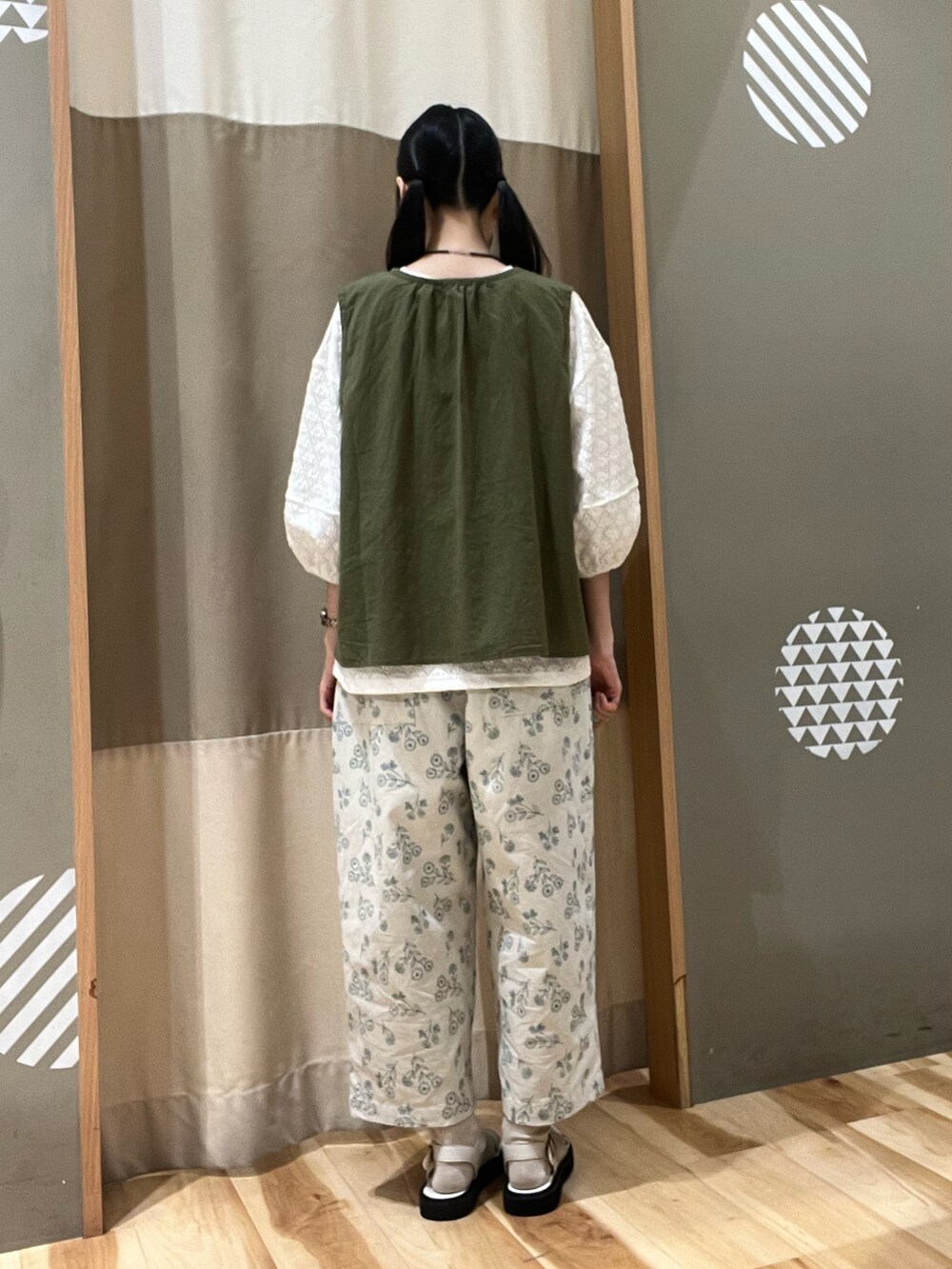 ホワイト系のサンダル、ホワイト系のその他パンツ、グリーン系のベストを着用したレディースの夏コーディネートの3枚目の写真