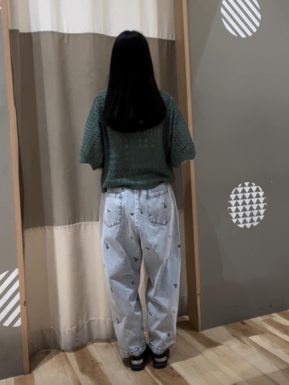 ゴールド系のハンドバッグ、グリーン系のカーディガン/ボレロ、ブルー系のその他パンツを着用したレディースの春コーディネートの3枚目の写真