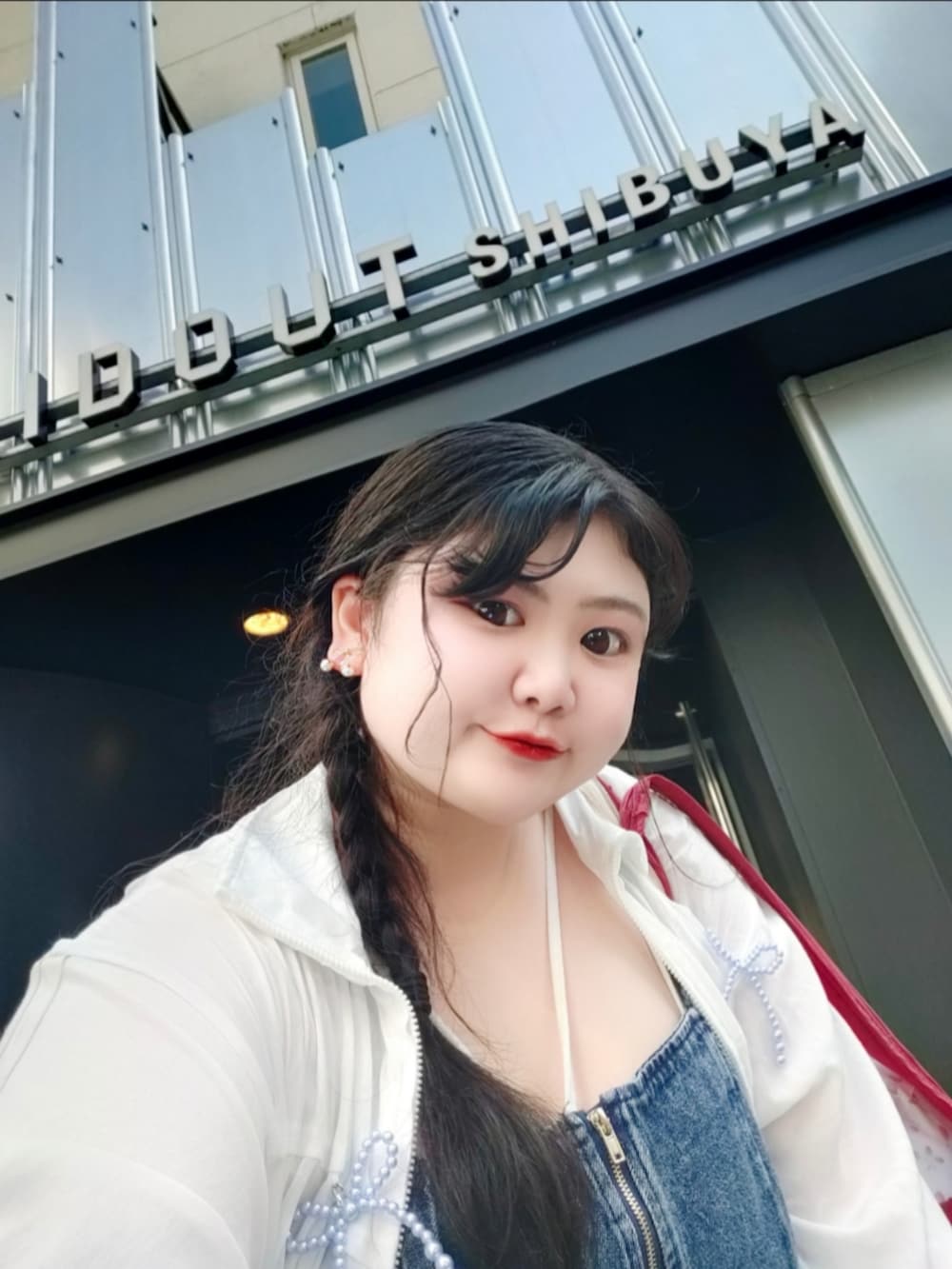 ホワイト系のマウンテンパーカー、ブルー系のキャミソール、ホワイト系のキャミソールを着用したレディースの夏コーディネートの4枚目の写真