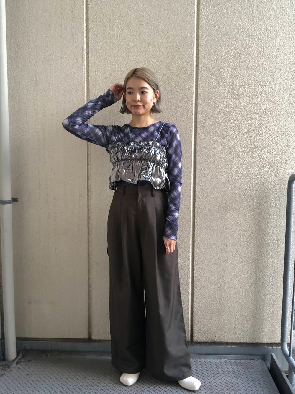 ホワイト系のブーツ、グリーン系のスラックス、シルバー系のベストを着用したレディースの夏コーディネートの5枚目の写真