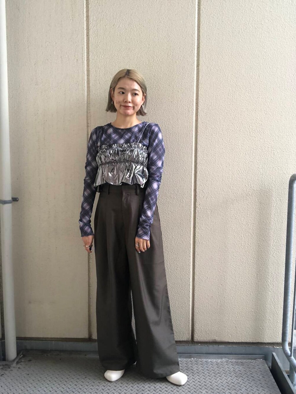 ホワイト系のブーツ、グリーン系のスラックス、シルバー系のベストを着用したレディースの夏コーディネートの2枚目の写真