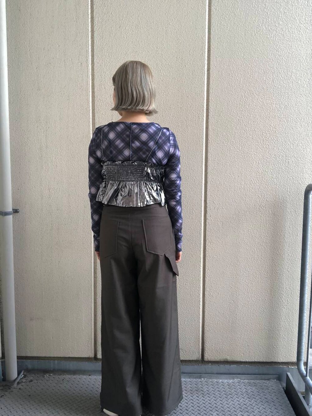 ホワイト系のブーツ、グリーン系のスラックス、シルバー系のベストを着用したレディースの夏コーディネートの4枚目の写真