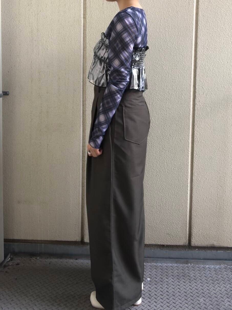 ホワイト系のブーツ、グリーン系のスラックス、シルバー系のベストを着用したレディースの夏コーディネートの3枚目の写真