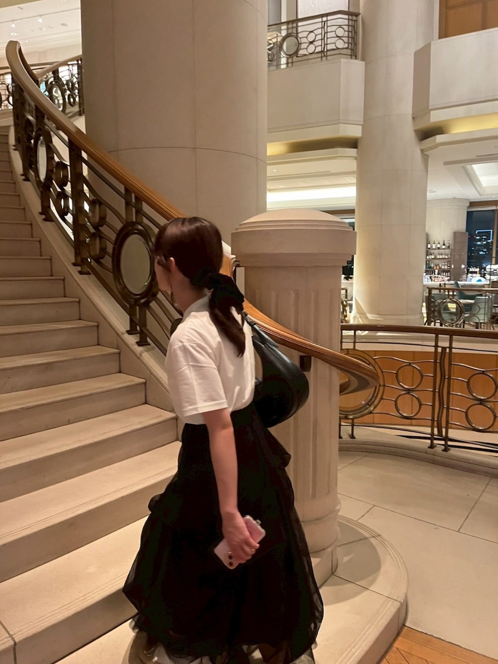 ホワイト系のTシャツ/カットソー、ブラック系のスカート、ブラック系のショルダーバッグを着用したレディースの夏コーディネートの2枚目の写真