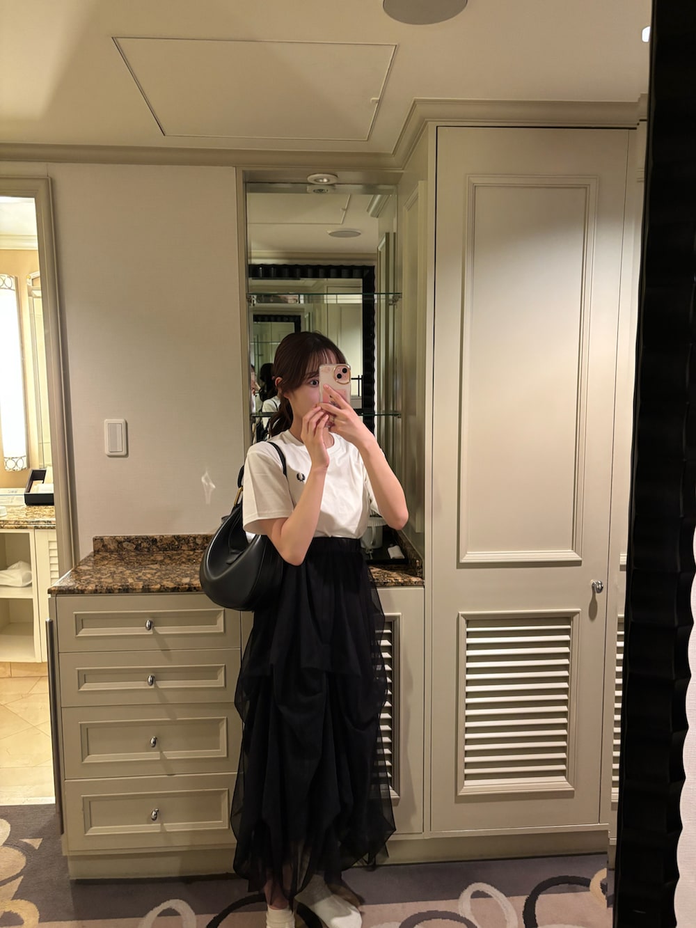 ホワイト系のTシャツ/カットソー、ブラック系のスカート、ブラック系のショルダーバッグを着用したレディースの夏コーディネートの4枚目の写真