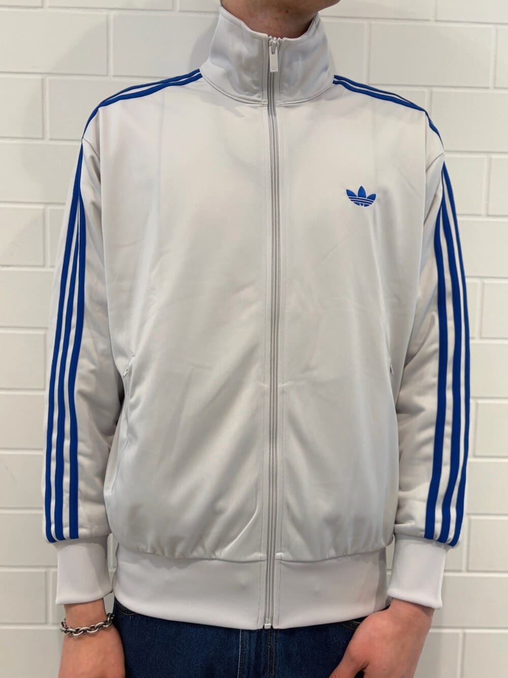 ブルー系のデニムパンツ、グレー系のトップス、シルバー系のスニーカーを着用したメンズの春コーディネートの4枚目の写真