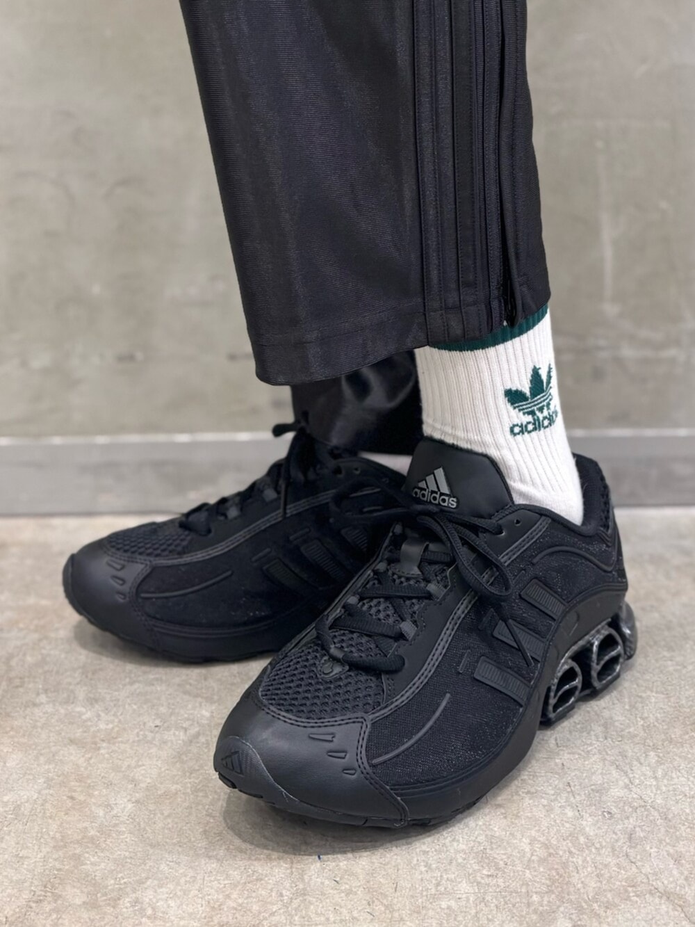 ホワイト系のTシャツ/カットソー、ブラック系のスニーカー、ブラック系のスウェットパンツを着用したメンズの夏コーディネートの6枚目の写真