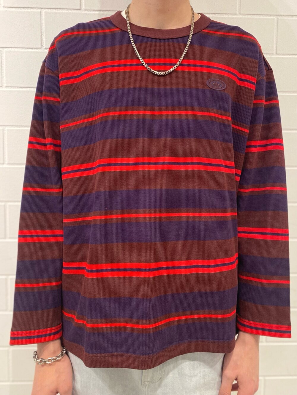 ブラウン系のスニーカー、レッド系のTシャツ/カットソー、ブルー系のその他パンツを着用したメンズの冬コーディネートの4枚目の写真