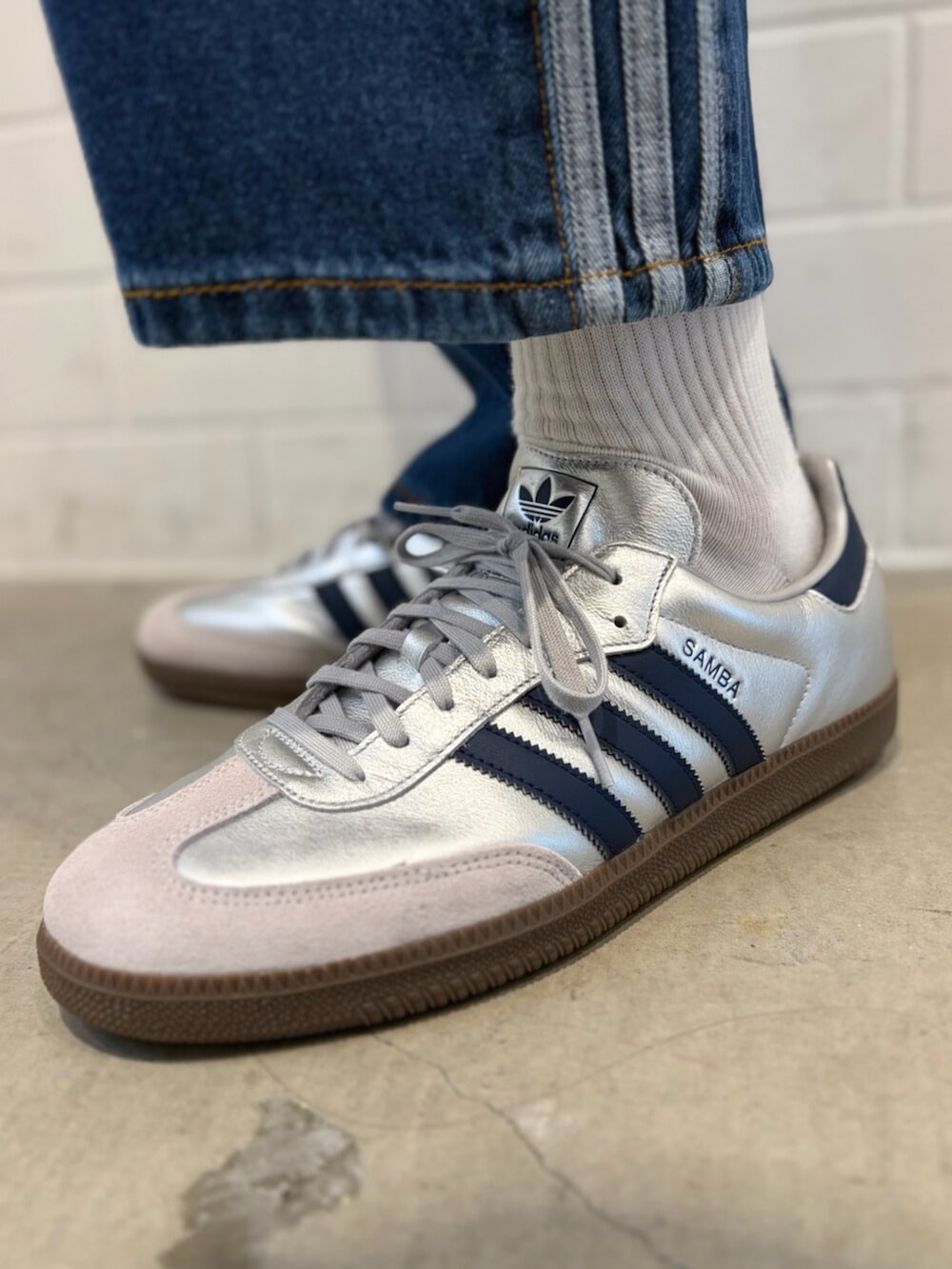 ブルー系のデニムパンツ、グレー系のトップス、シルバー系のスニーカーを着用したメンズの春コーディネートの6枚目の写真