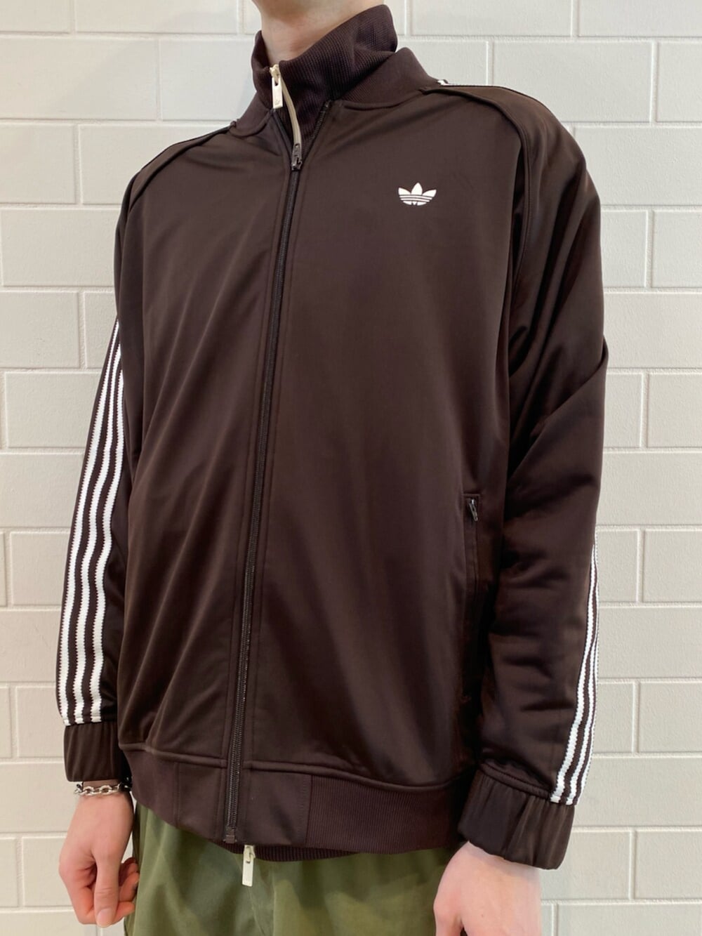 ホワイト系のジャージ、ブラウン系のジャージ、ベージュ系のスニーカーを着用したメンズの冬コーディネートの4枚目の写真