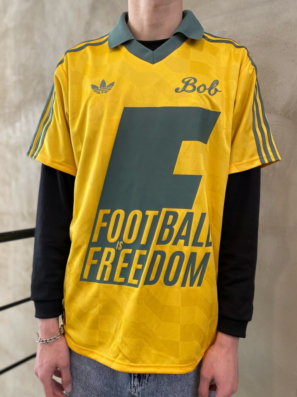 ブラック系のシューズ、グレー系のデニムパンツ、イエロー系のトップスを着用したメンズの冬コーディネートの4枚目の写真