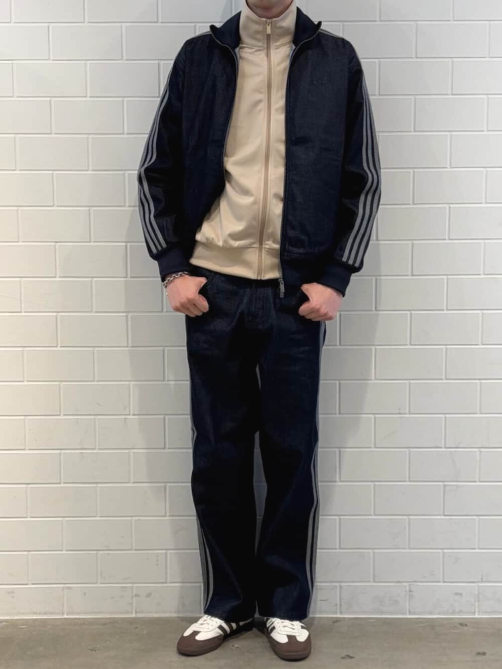 ホワイト系のスニーカー、ブルー系のデニムジャケット、ブルー系のその他パンツを着用したメンズの春コーディネートの2枚目の写真