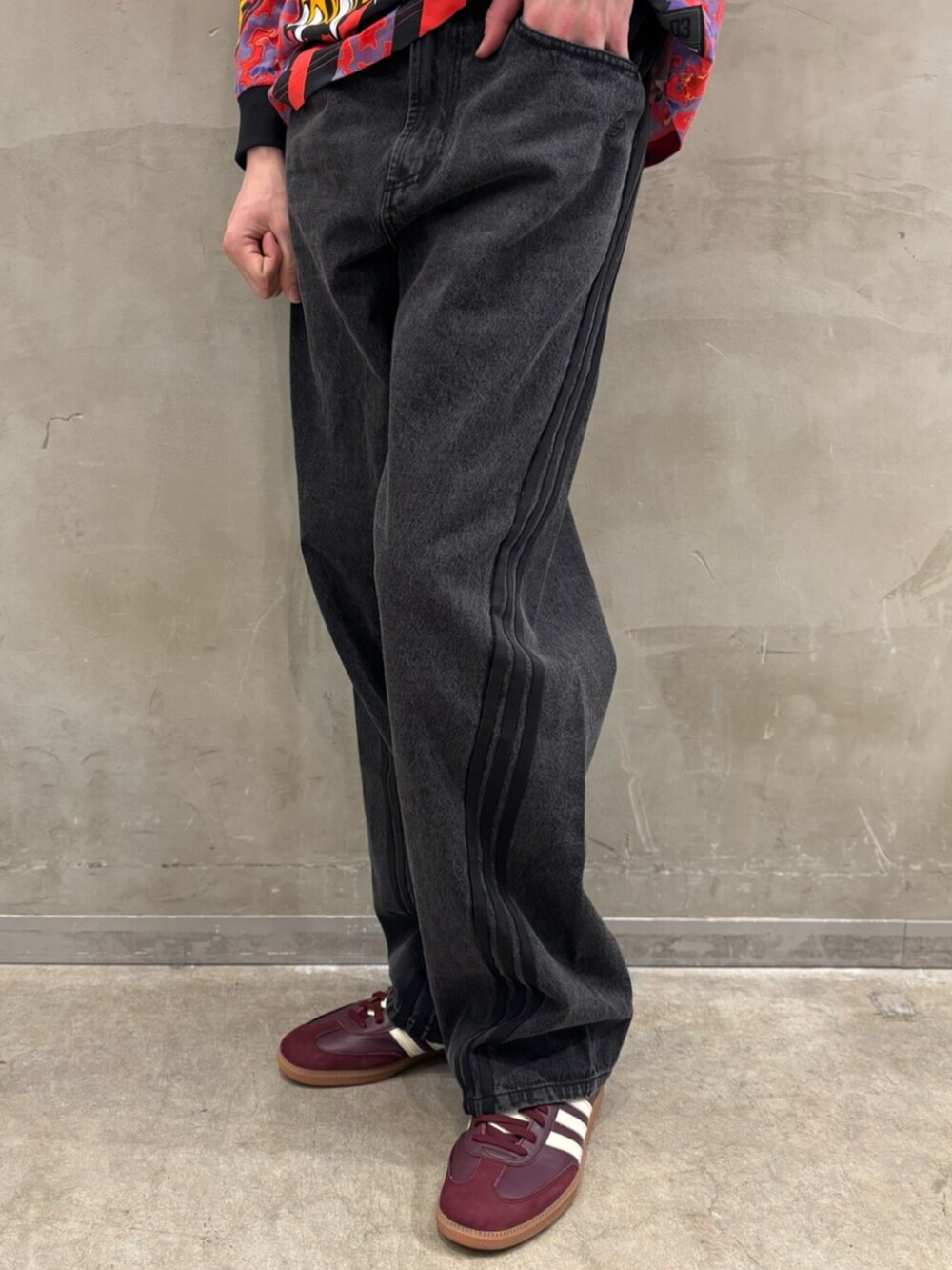 レッド系のスニーカー、ブラック系のデニムジャケット、ブラック系のデニムパンツを着用したメンズの冬コーディネートの7枚目の写真