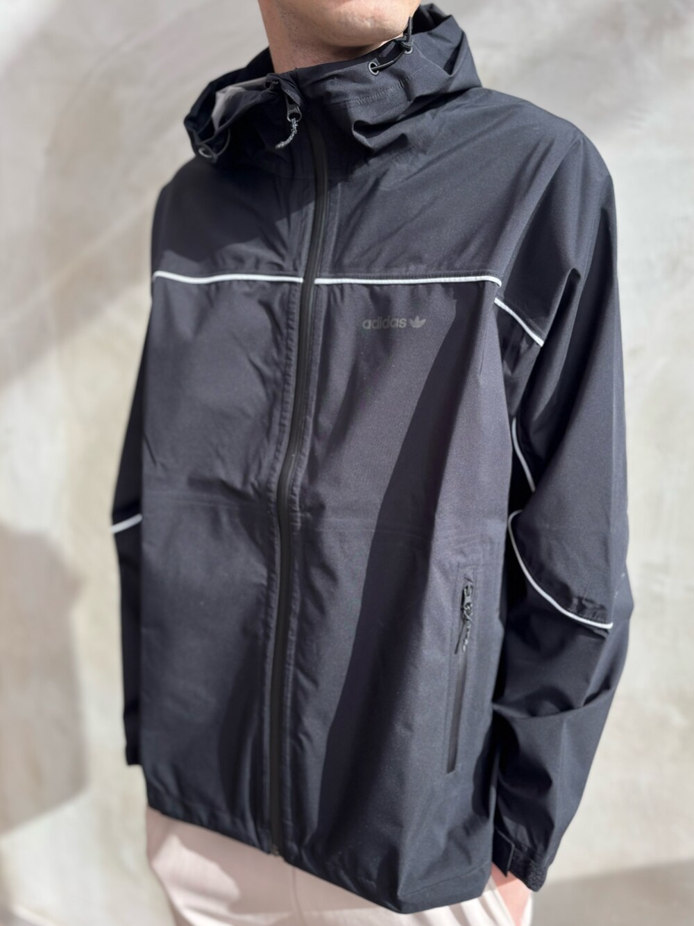 ブラック系のマウンテンパーカー、ベージュ系のその他パンツ、ブラウン系のスニーカーを着用したメンズの冬コーディネートの4枚目の写真