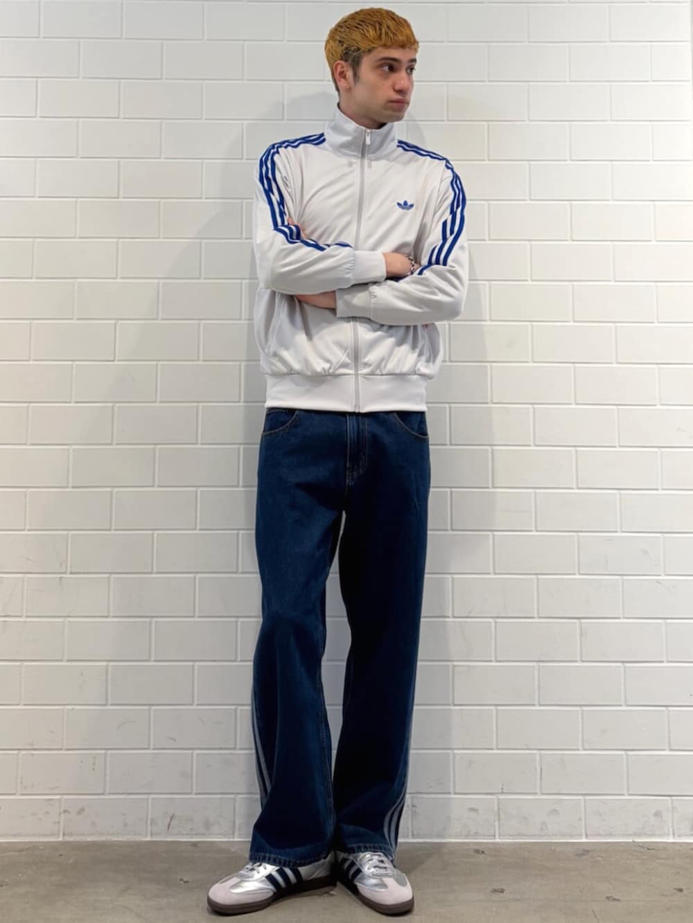 ブルー系のデニムパンツ、グレー系のトップス、シルバー系のスニーカーを着用したメンズの春コーディネートの3枚目の写真