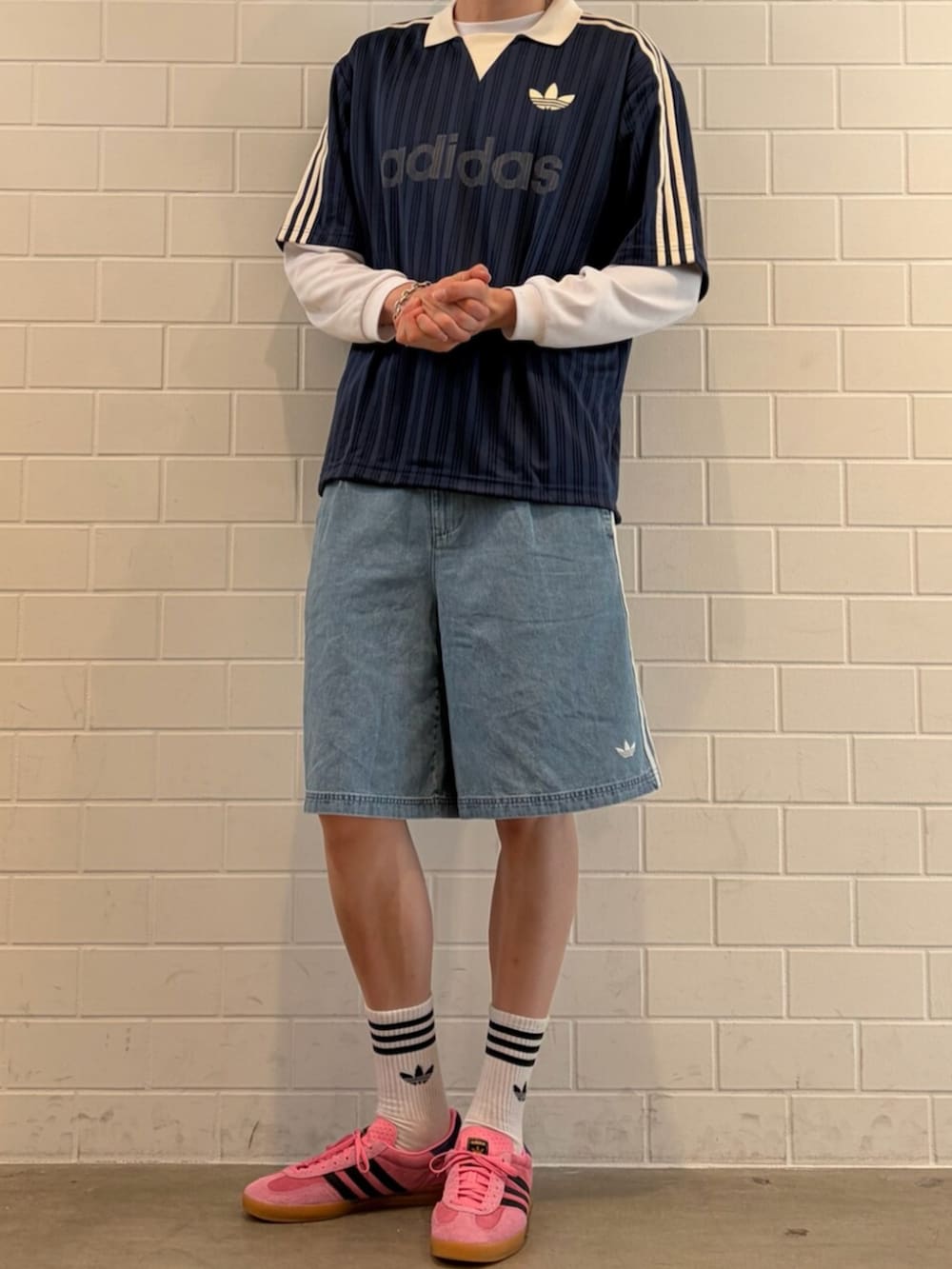 ブルー系のTシャツ/カットソー、ピンク系のスニーカー、ブルー系のデニムパンツを着用したメンズの夏コーディネートの2枚目の写真