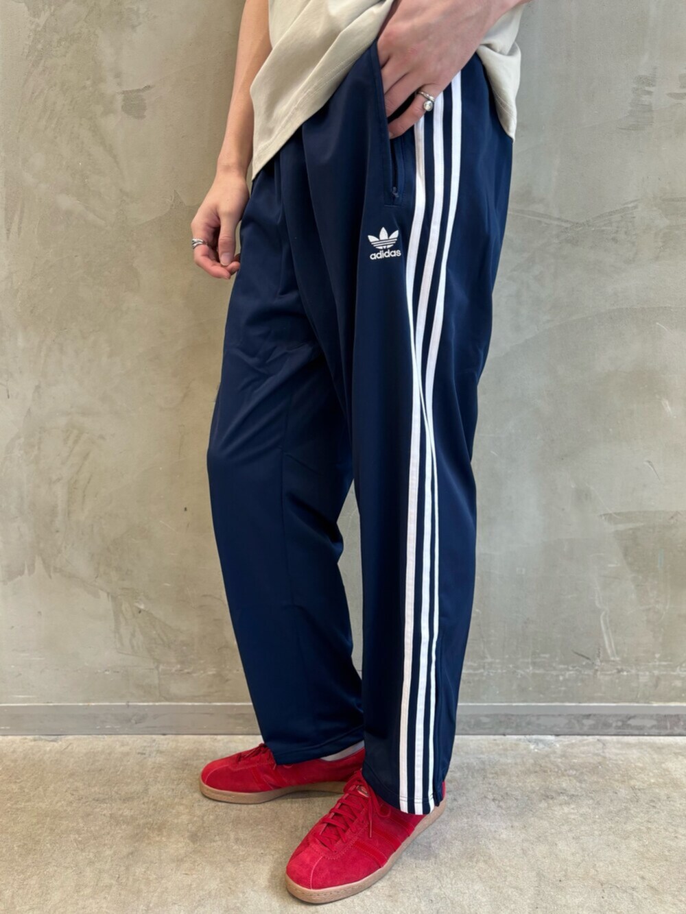 ブルー系のスウェットパンツ、ベージュ系のTシャツ/カットソー、レッド系のスニーカーを着用したメンズの春コーディネートの7枚目の写真