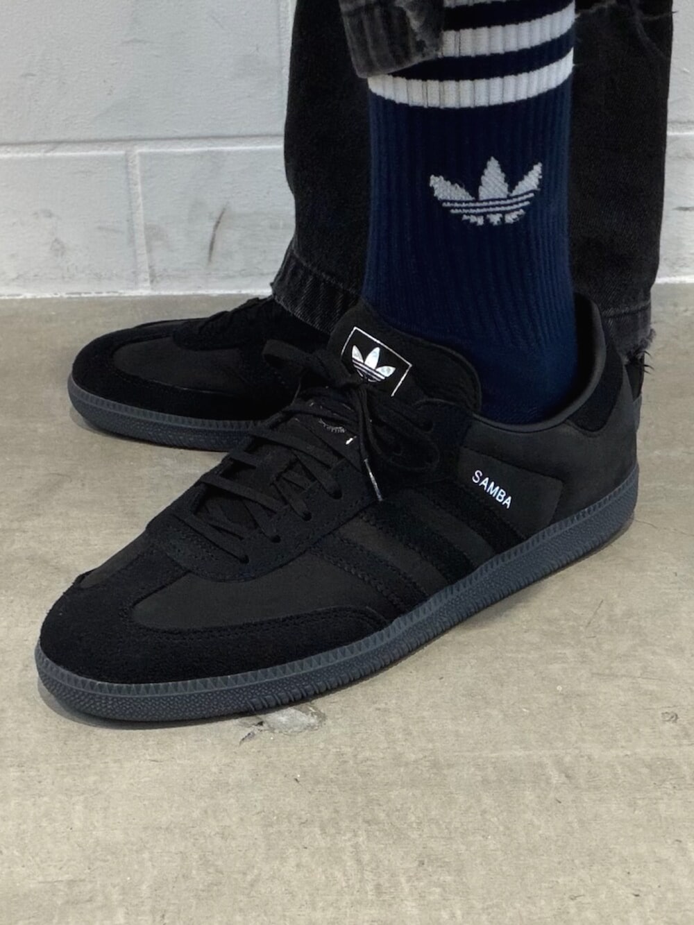 グレー系のトップス、ブラック系のスニーカーを着用したメンズの春コーディネートの4枚目の写真