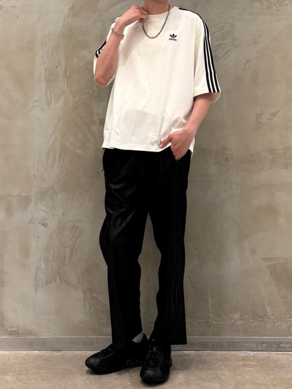 ホワイト系のTシャツ/カットソー、ブラック系のスニーカー、ブラック系のスウェットパンツを着用したメンズの夏コーディネートの2枚目の写真