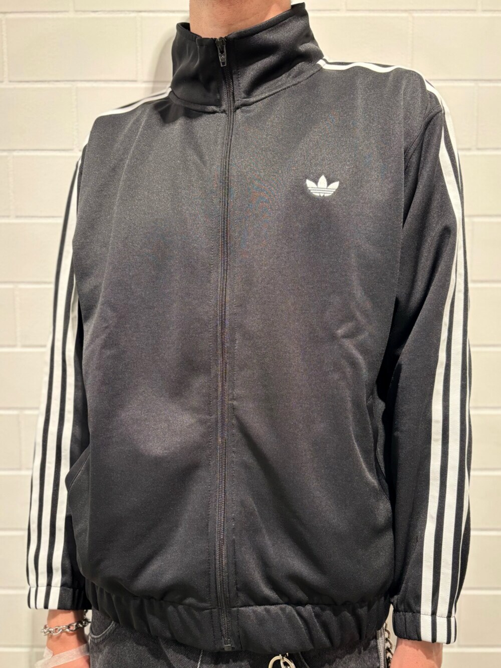 ブラック系のデニムパンツ、ホワイト系のシューズ、ブラック系のジャージを着用したメンズの秋コーディネートの4枚目の写真