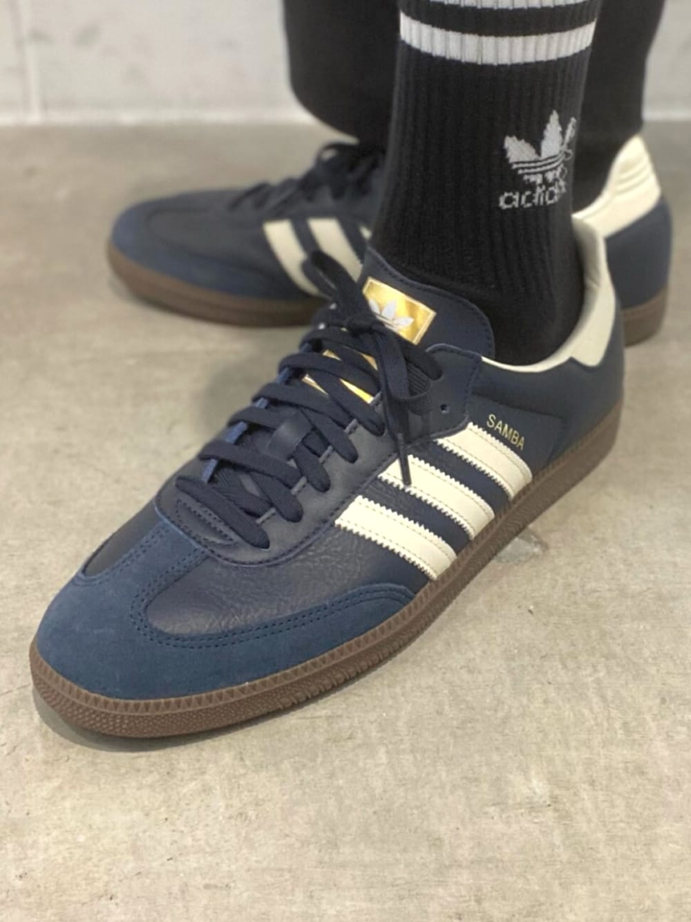 ブルー系のスニーカー、グリーン系のポロシャツを着用したメンズの冬コーディネートの4枚目の写真