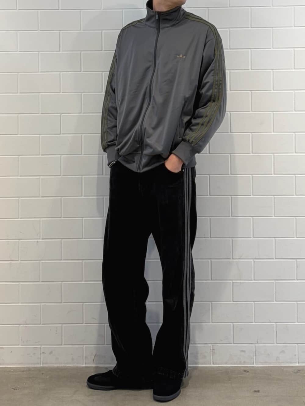 グレー系のトップス、ブラック系のスニーカーを着用したメンズの春コーディネートの2枚目の写真