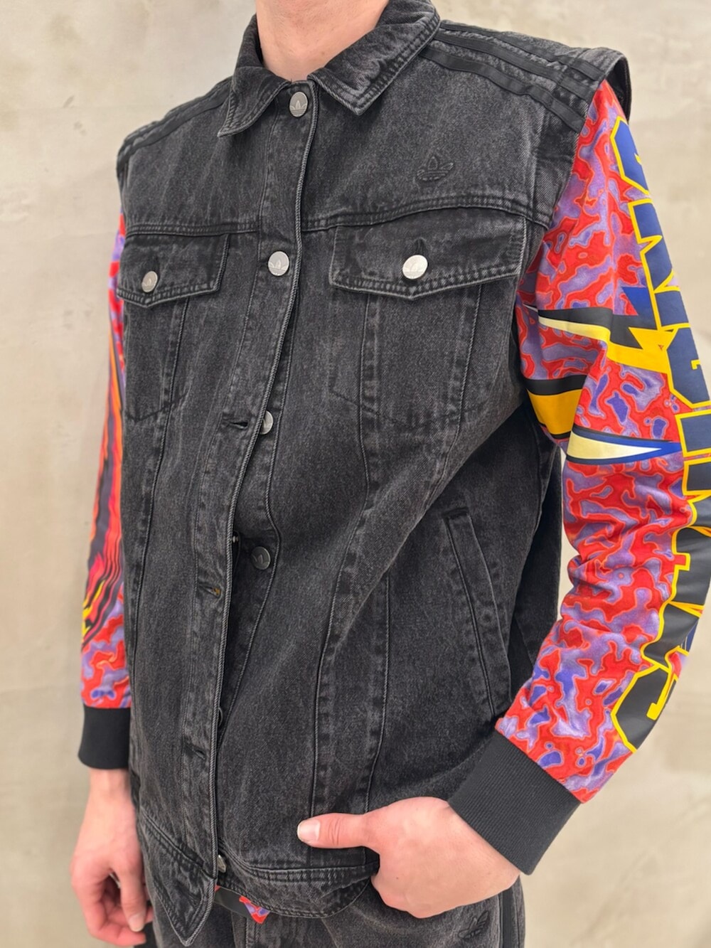 レッド系のスニーカー、ブラック系のデニムジャケット、ブラック系のデニムパンツを着用したメンズの冬コーディネートの4枚目の写真