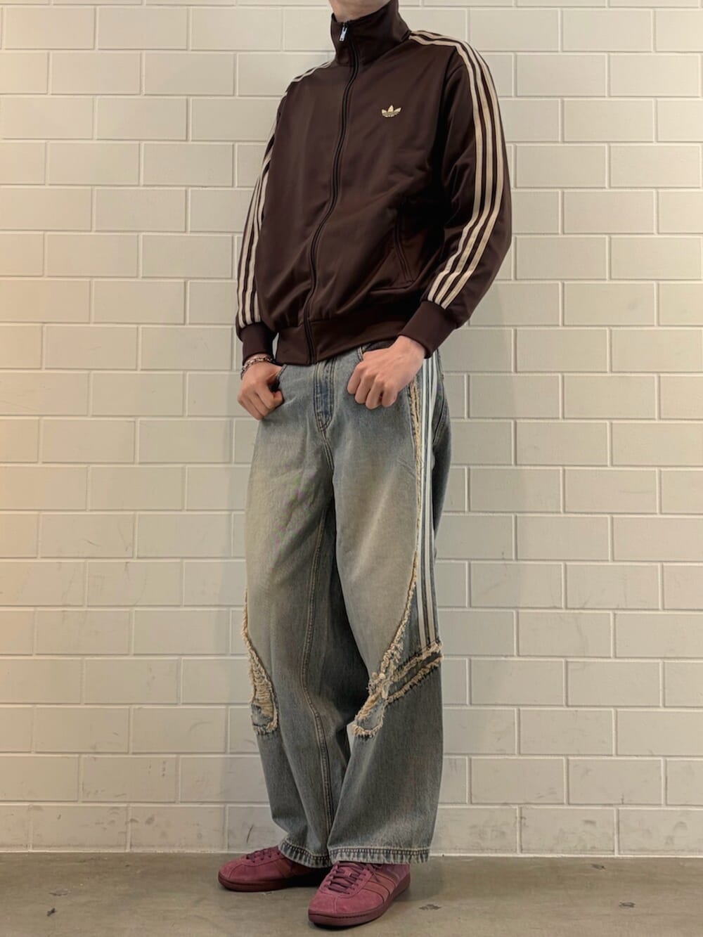 ブルー系のデニムパンツ、ブラウン系のジャージ、レッド系のシューズを着用したメンズの春コーディネートの2枚目の写真