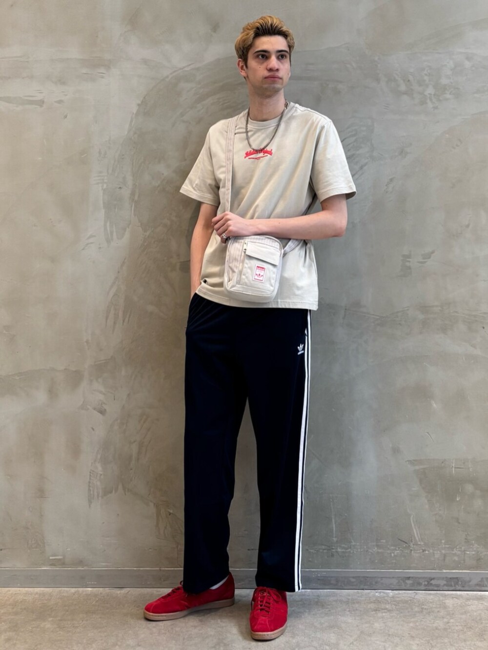 ブルー系のスウェットパンツ、ベージュ系のTシャツ/カットソー、レッド系のスニーカーを着用したメンズの春コーディネートの3枚目の写真