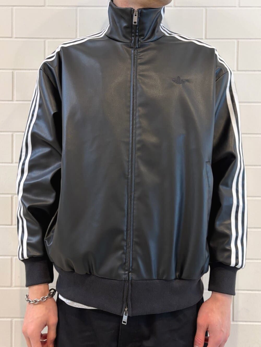 ブルー系のスニーカー、ブルー系のデニムジャケット、ブラック系のブルゾンを着用したメンズの春コーディネートの5枚目の写真