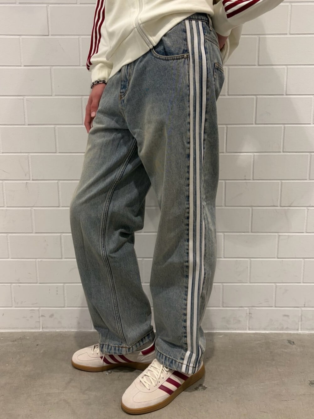 ブルー系のデニムパンツ、ホワイト系のトップス、ホワイト系のシューズを着用したメンズの春コーディネートの5枚目の写真