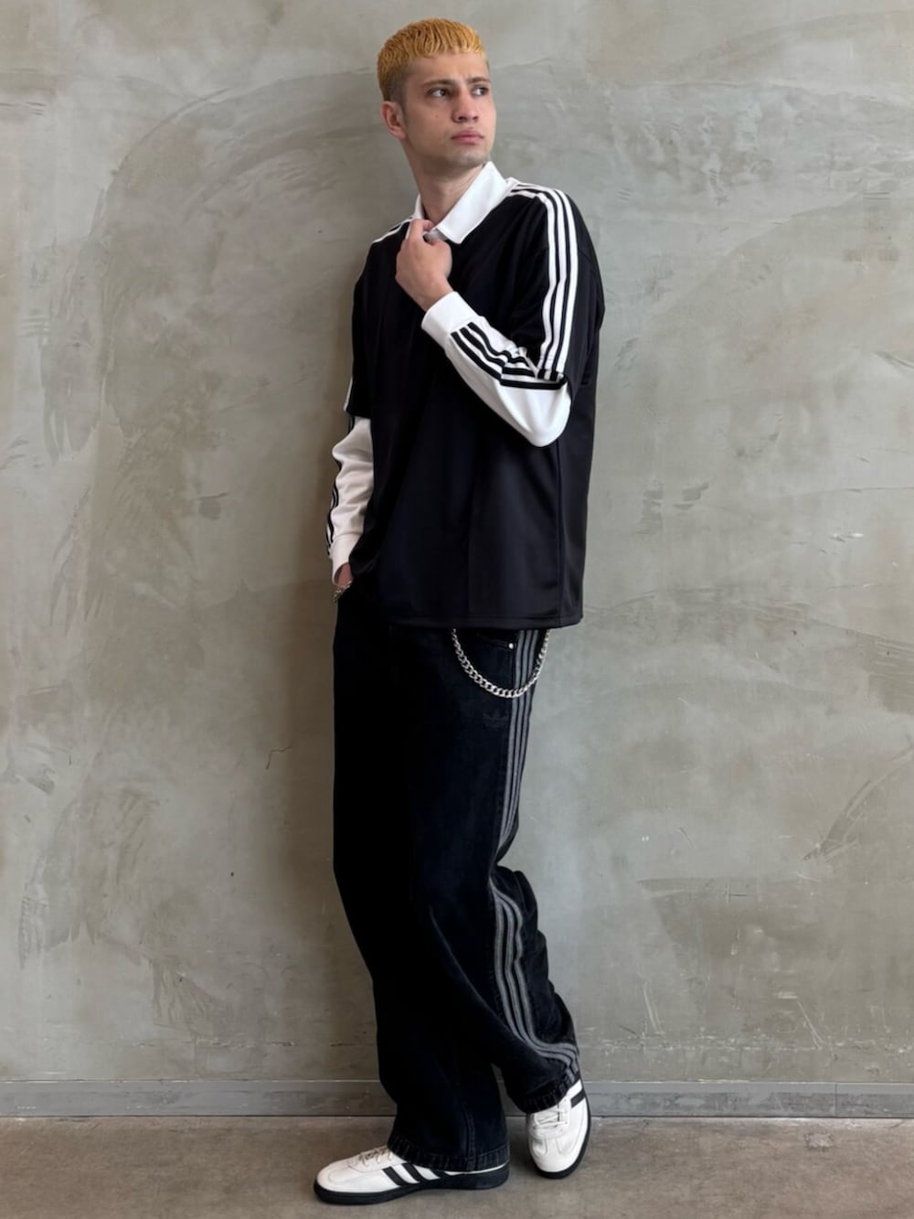 ホワイト系のポロシャツ、ブラック系のTシャツ/カットソー、ホワイト系のスニーカーを着用したメンズの夏コーディネートの3枚目の写真