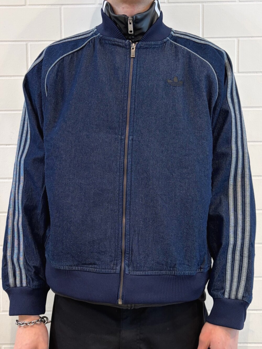 ブルー系のスニーカー、ブルー系のデニムジャケット、ブラック系のブルゾンを着用したメンズの春コーディネートの4枚目の写真