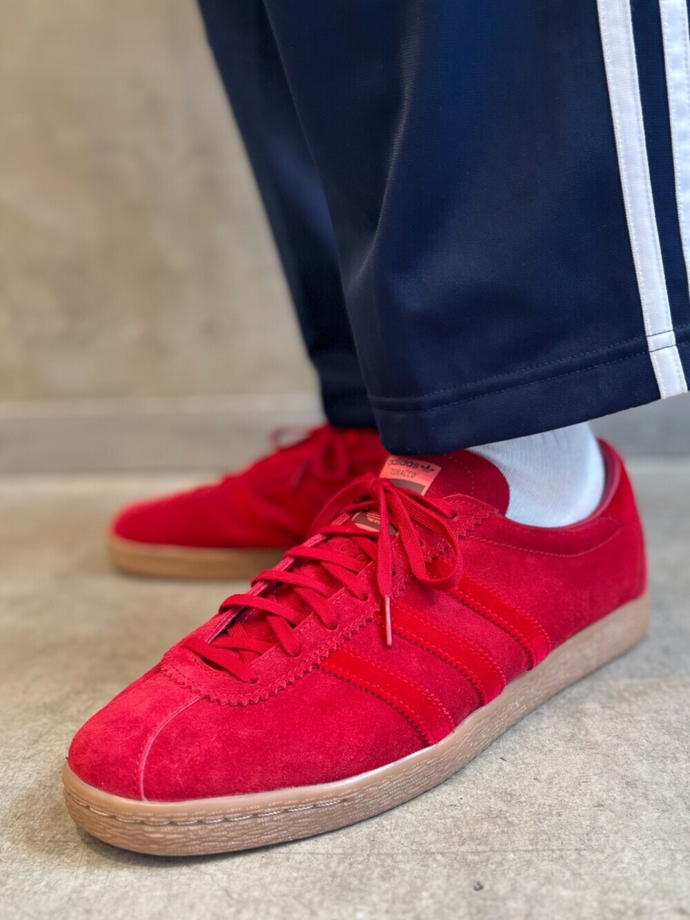 ブルー系のスウェットパンツ、ベージュ系のTシャツ/カットソー、レッド系のスニーカーを着用したメンズの春コーディネートの8枚目の写真