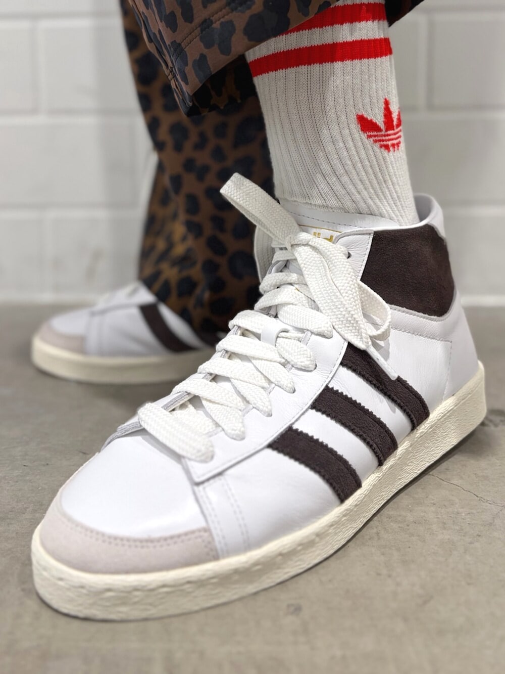 ブラック系のジャージ、ブラウン系のその他パンツ、ホワイト系のスニーカーを着用したメンズの春コーディネートの6枚目の写真