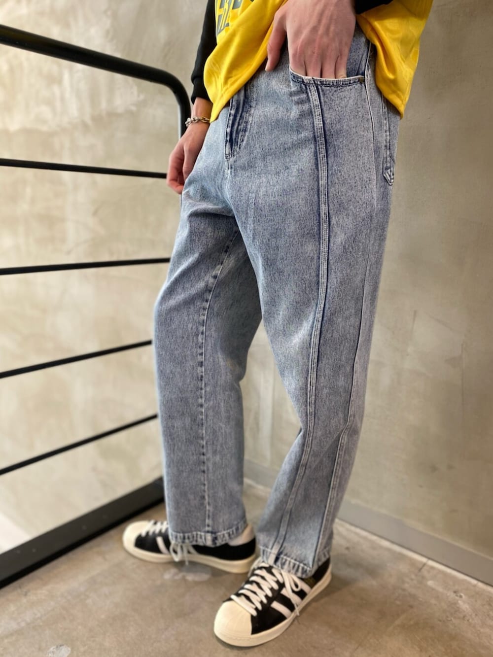 ブラック系のシューズ、グレー系のデニムパンツ、イエロー系のトップスを着用したメンズの冬コーディネートの5枚目の写真