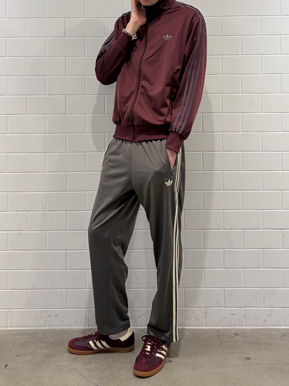 レッド系のスニーカー、レッド系のジャージ、グレー系のその他パンツを着用したメンズの春コーディネートの2枚目の写真