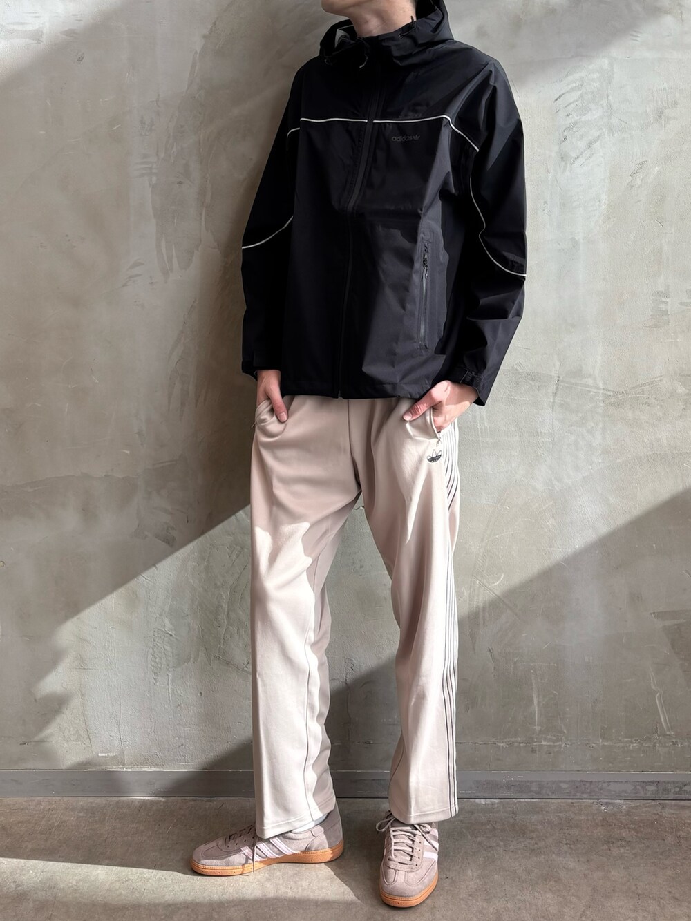 ブラック系のマウンテンパーカー、ベージュ系のその他パンツ、ブラウン系のスニーカーを着用したメンズの冬コーディネートの2枚目の写真