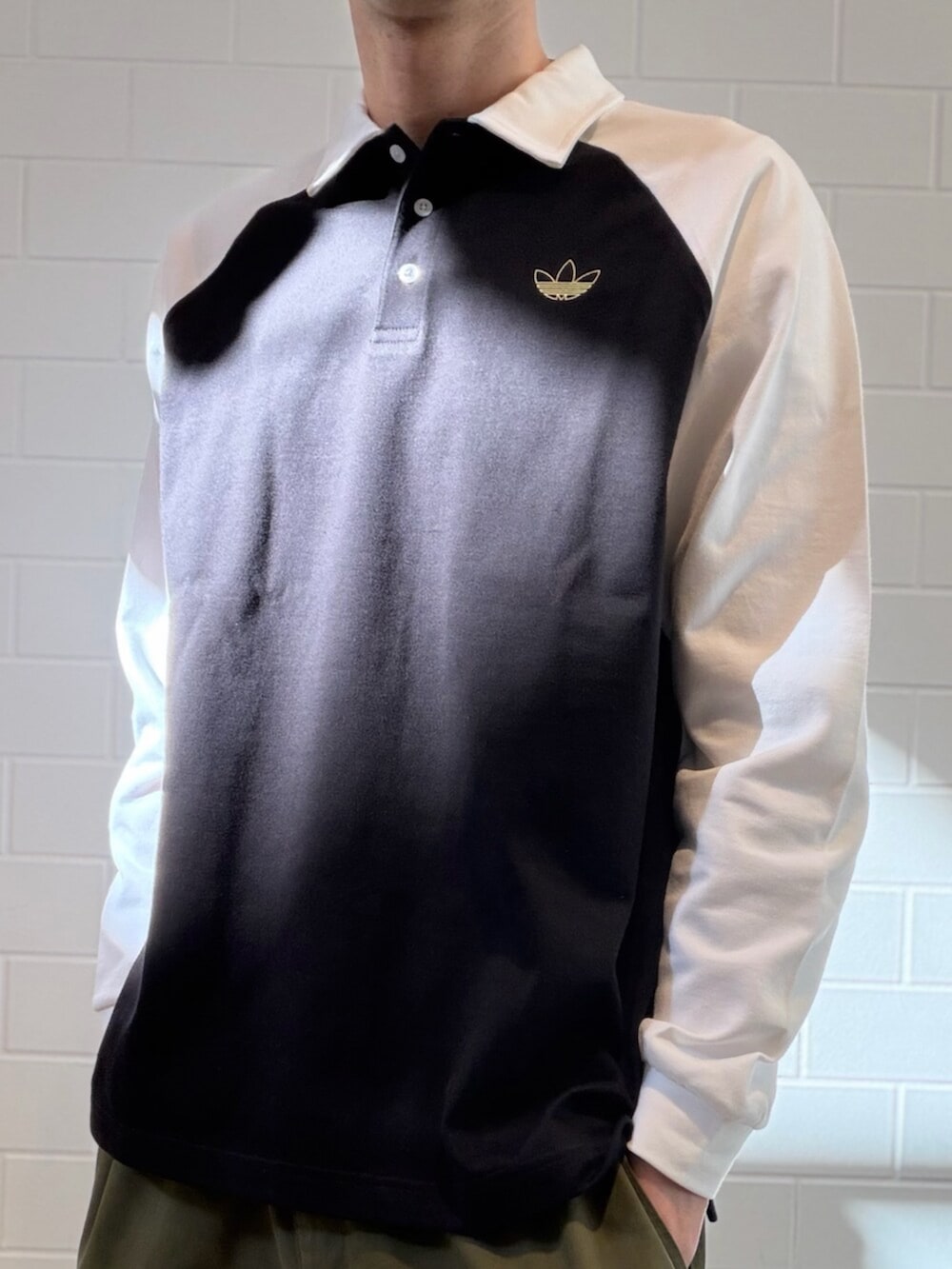 ブラック系のポロシャツ、ベージュ系のスニーカーを着用したメンズの冬コーディネートの3枚目の写真