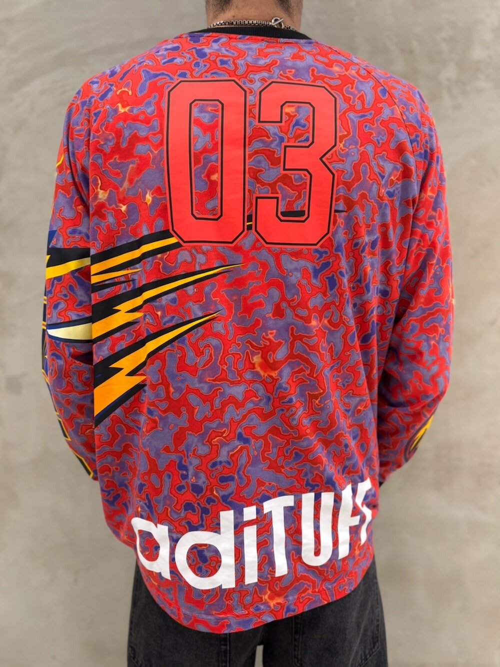 レッド系のスニーカー、ブラック系のデニムジャケット、ブラック系のデニムパンツを着用したメンズの冬コーディネートの6枚目の写真