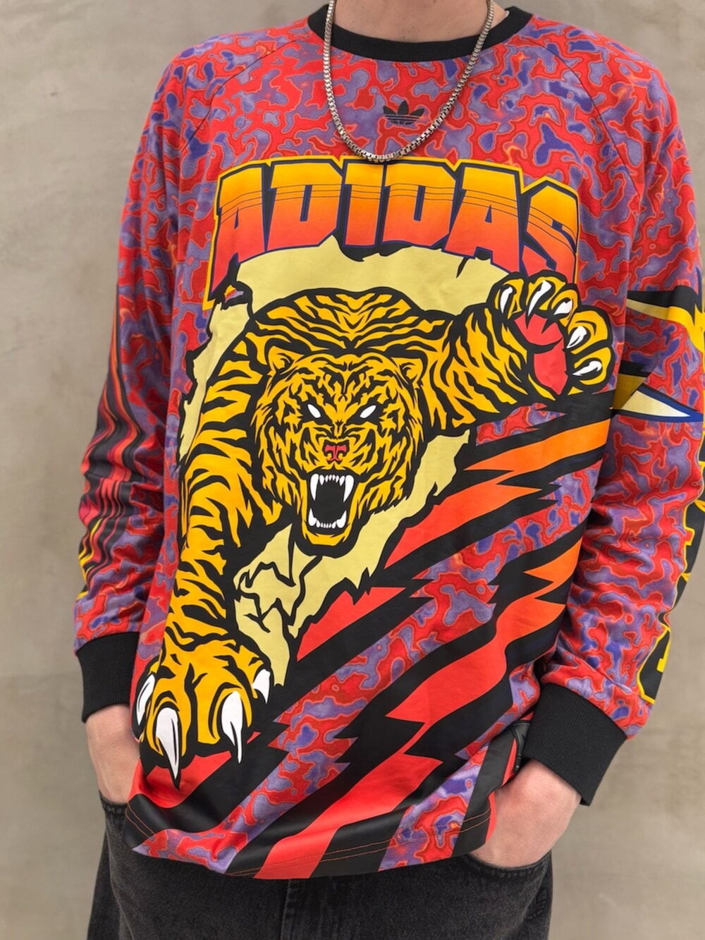 レッド系のスニーカー、ブラック系のデニムジャケット、ブラック系のデニムパンツを着用したメンズの冬コーディネートの5枚目の写真