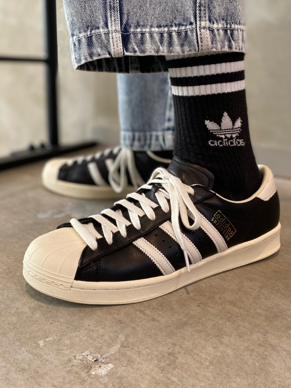 ブラック系のシューズ、グレー系のデニムパンツ、イエロー系のトップスを着用したメンズの冬コーディネートの6枚目の写真