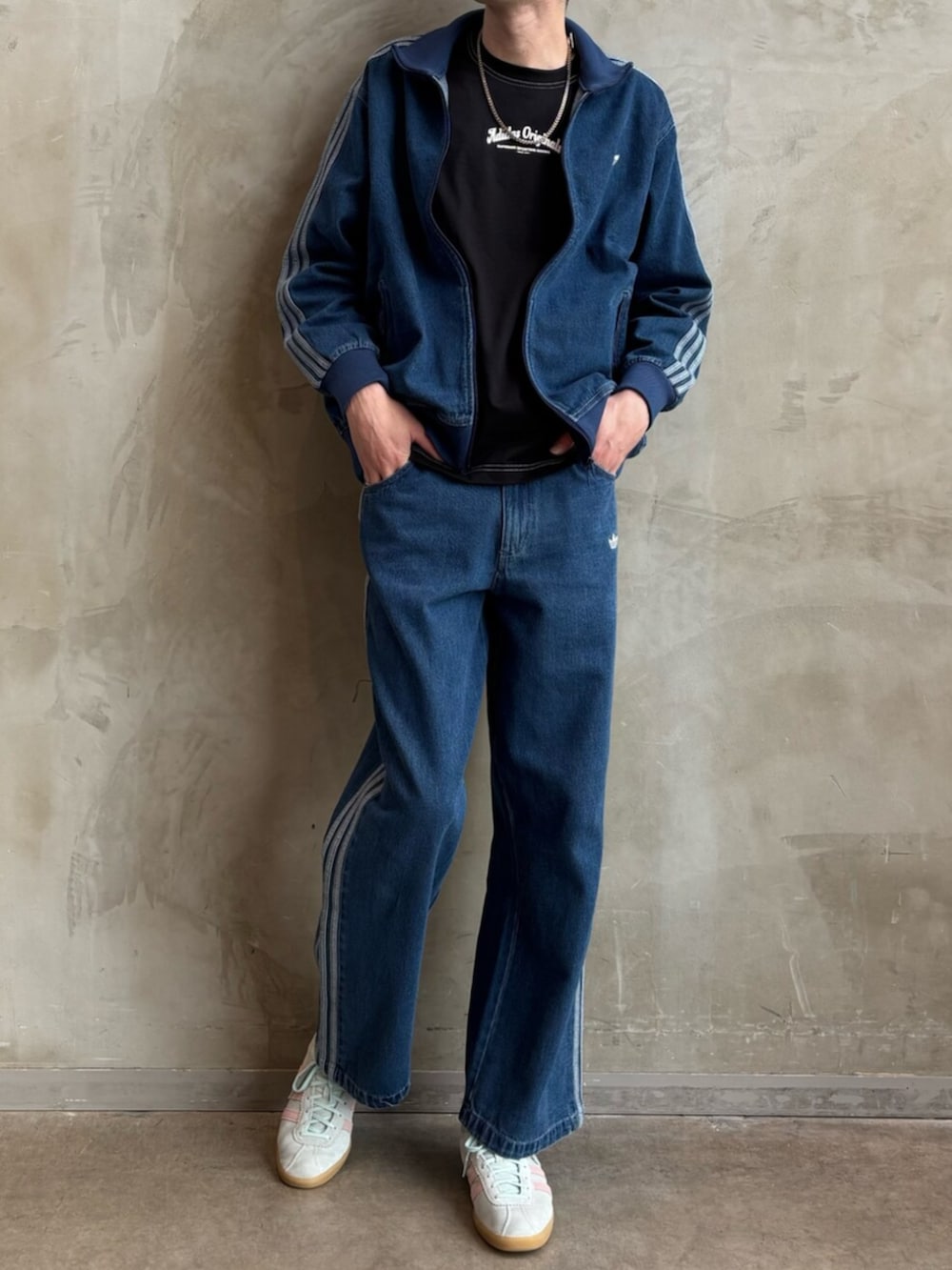 ブルー系のデニムパンツ、グリーン系のスニーカー、ブラック系のTシャツ/カットソーを着用したメンズの春コーディネートの2枚目の写真
