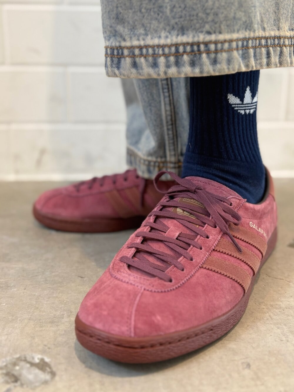 ブルー系のデニムパンツ、ブラウン系のジャージ、レッド系のシューズを着用したメンズの春コーディネートの6枚目の写真