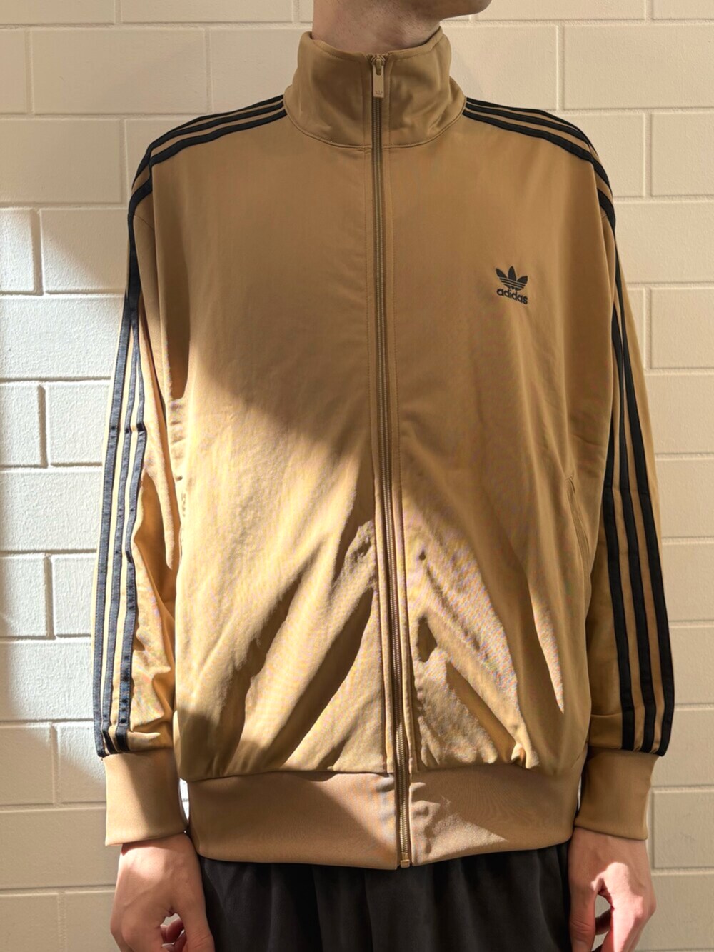 ブラウン系のジャージ、ブラック系のジャージ、ブラウン系のスニーカーを着用したメンズの秋コーディネートの4枚目の写真