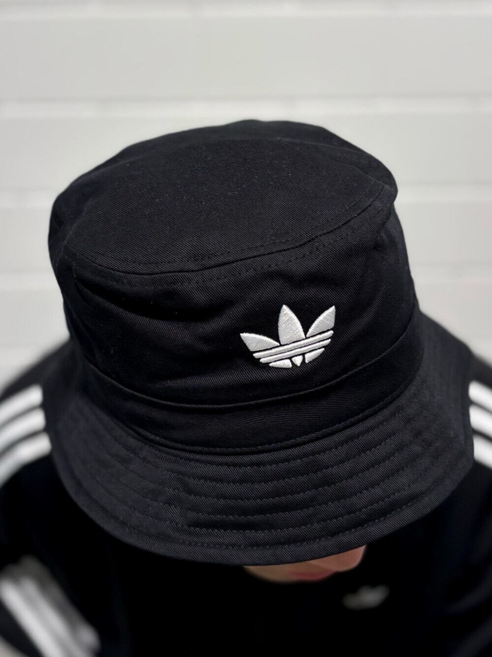 ブラック系のデニムパンツ、ホワイト系のシューズ、ブラック系のジャージを着用したメンズの秋コーディネートの3枚目の写真