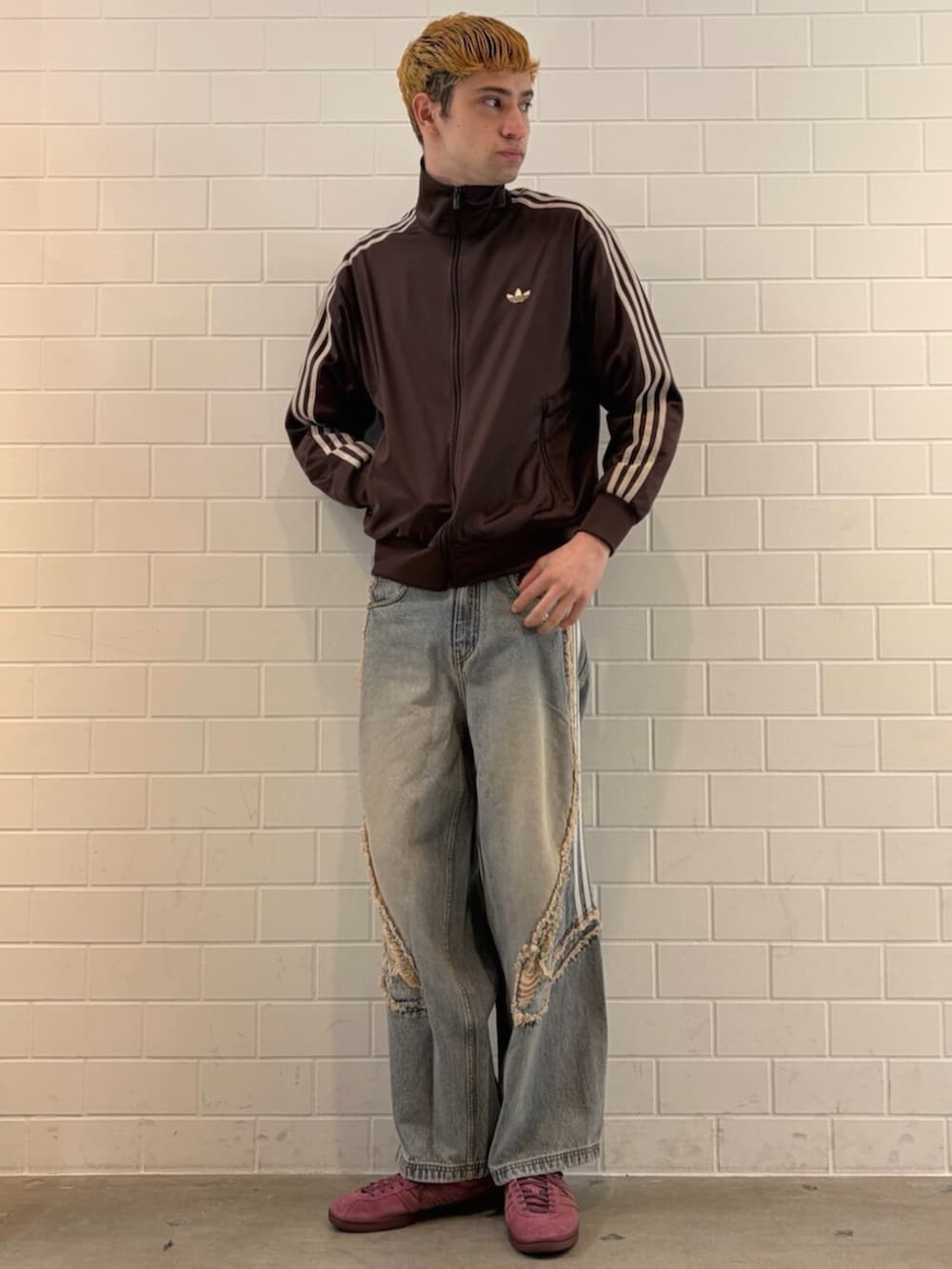 ブルー系のデニムパンツ、ブラウン系のジャージ、レッド系のシューズを着用したメンズの春コーディネートの3枚目の写真